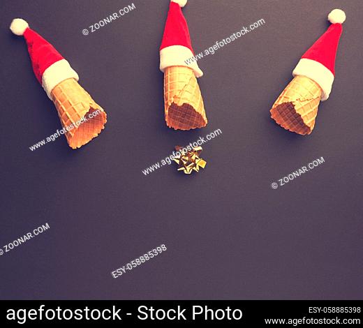 Golden bow fall out of an ice cream cone decorated with the Santa Claus hat