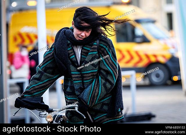 Illustration picture shows a woman struggling to keep her bike upright with high winds, in Oostende as storm Corrie hits the Belgian coast of the North Sea