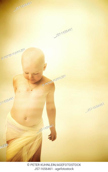Young girl with cancer playing in studio with scarf
