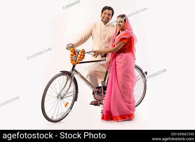 A HAPPY RURAL COUPLE POSING TOGETHER WITH NEW BICYCLE