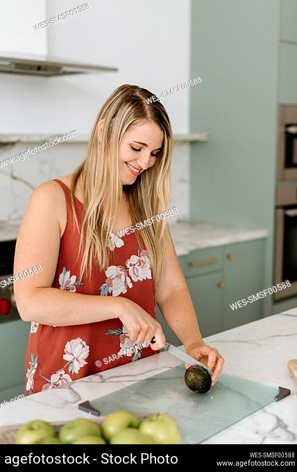 Female nutrient expert chopping food on cutting board in kitchen