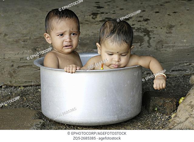 Warli babies bathing in a vessel