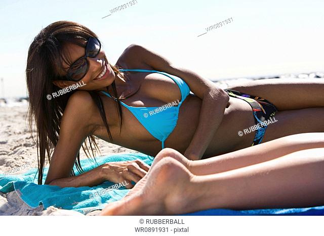 Two young women sunbathing on the beach