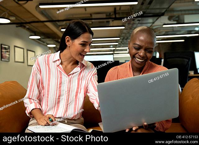 Happy businesswoman working at laptop in office