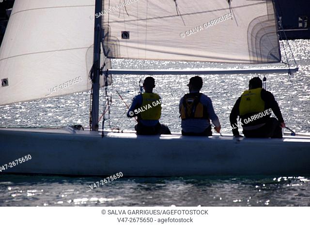 Three people sailing on a sailboat in Valencia, Spain, Europe