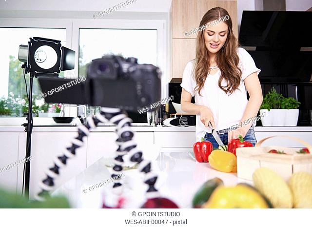 Woman recording while chopping vegetables