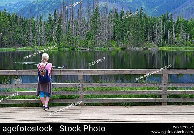 by the Smreczynski Pond, young wooman, blonde, black water, forest, dead trees