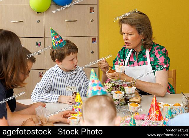 Queen Mathilde of Belgium decorates a cupcake with a boy (Tygo) during a royal visit to De Kindervriend, a multifunctional center for children with intellectual...