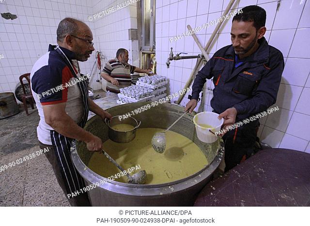 09 May 2019, Iraq, Baghdad: Iraqi men prepare Iftar food for the needy at the shrine of Sheikh Abdul Kader al-Kilani on the fourth day of the Muslim holy month...