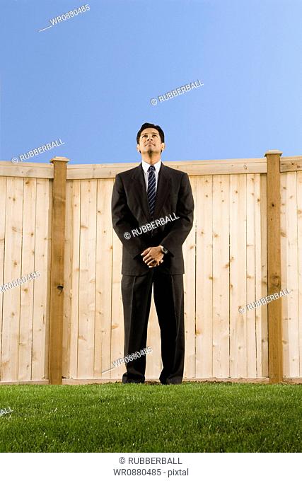 Low angle view of a businessman standing in a lawn
