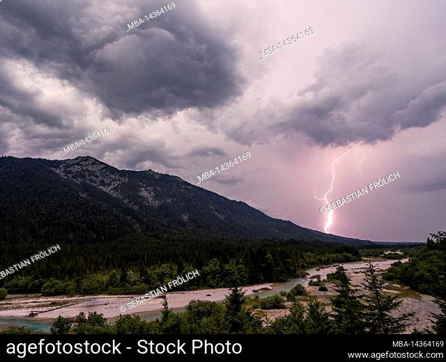 Thunderstorm over the Isar near Wallgau, lightning discharge and dark clouds, in the background partly light visibility to the zugspitze and the...