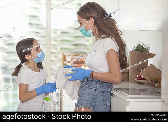mother with mask and gloves talks to her daughter