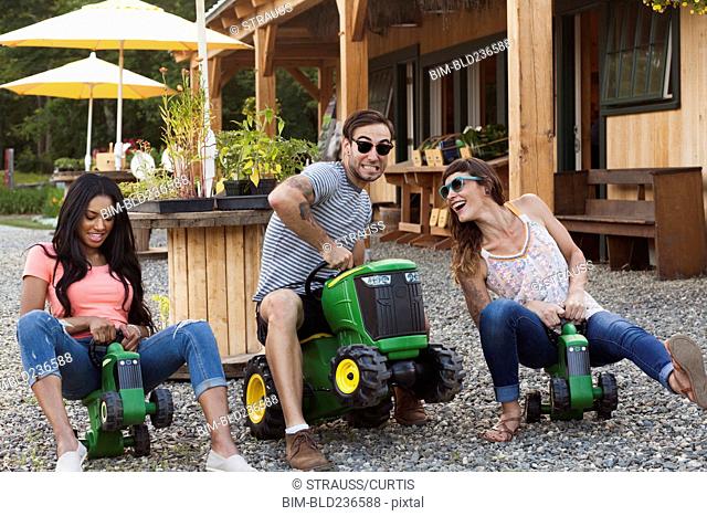 Friends playing on toy tractors