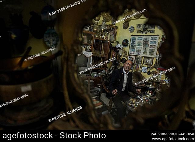 16 June 2021, Iraq, Mosul: Iraqi Fakhri Suleiman Al-Tai sits at his house amongst artefacts and antique pieces that he collected after he returned to Mosul's...