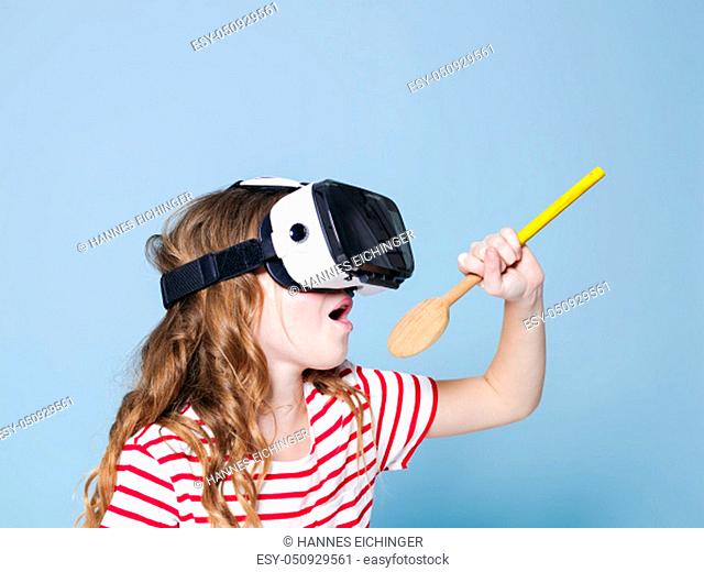 cool and smiling positive girl wearing virtual reality glasses goggles headset is singing with cooking spoon, new generation