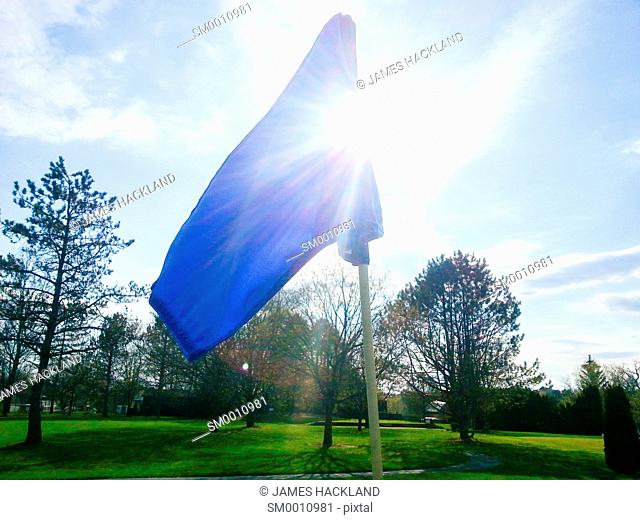 The flag atop the pin on the green of a golf course in Southern Ontario, Canada on a spring day