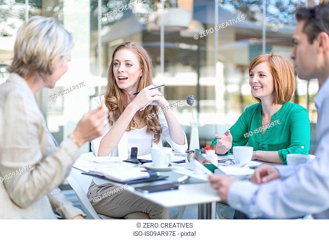 Businesswomen and man meeting at coffee break on hotel terrace