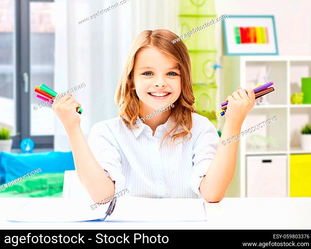 smiling girl with colorful felt-tip pens at home