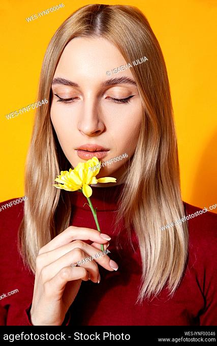 Woman holding flower in studio