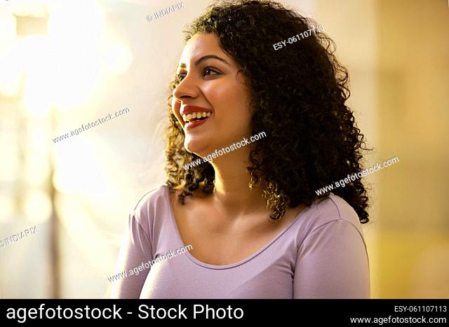 Adult young woman smiling while looking away
