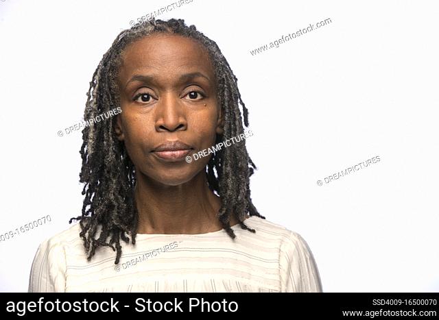 Portrait of middle aged black woman looking at camera with straight face
