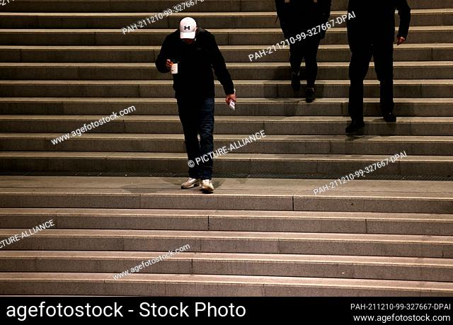 10 December 2021, North Rhine-Westphalia, Cologne: People walk down a flight of stairs at Central Station in the morning
