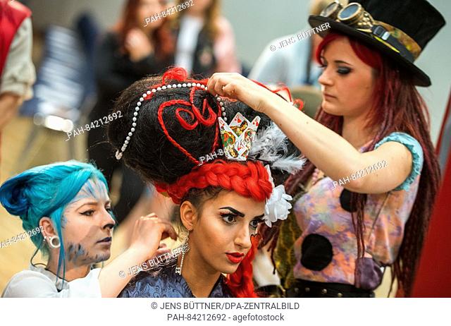 Model Tina, member of the team of the vocational college Rostock, is transformed into the Queen of Hearts from Alice in Wonderland by Lisa Meier (r) and Irina...