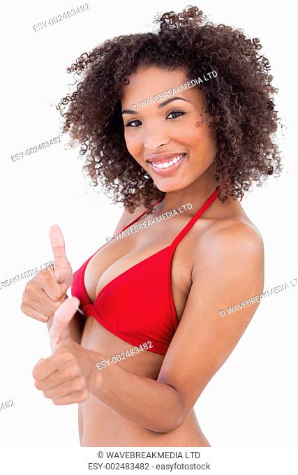 Attractive brunette woman looking at the camera while putting her thumbs up