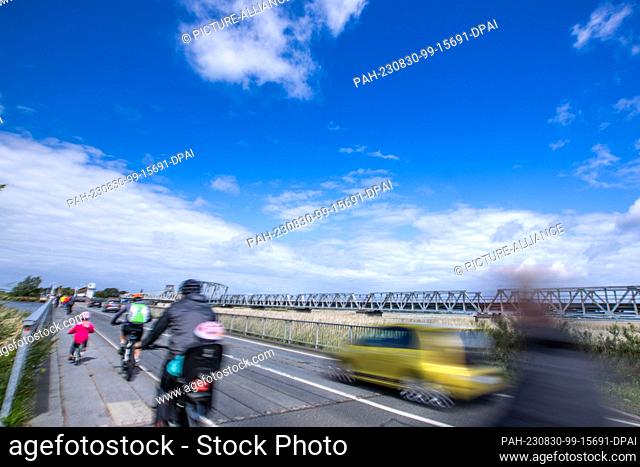 PRODUCTION - 10 August 2023, Mecklenburg-Western Pomerania, Pruchten: Car and bicycle traffic on the temporary bridge next to the old Meiningen Bridge between...