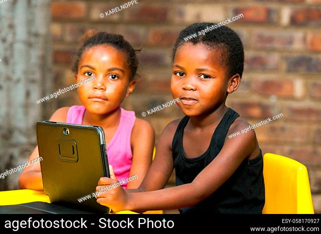 Close up portrait of two african kids with digital tablet outdoors