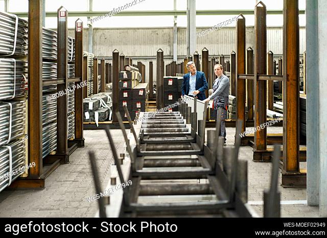 Businessman talking to worker in a factory
