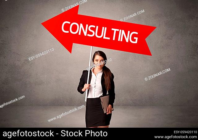 Young business person in casual holding road sign with CONSULTING inscription, business direction concept