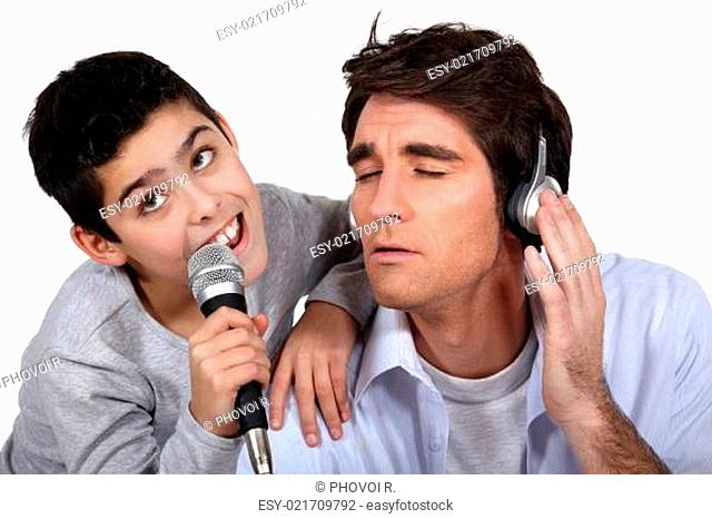 Father and son singing into a microphone