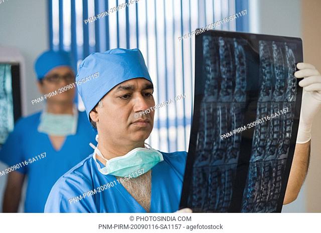 Surgeon examining an x-ray report, Gurgaon, Haryana, India