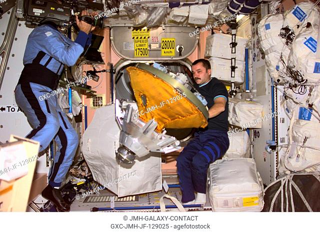 Cosmonaut Mikhail Tyurin, Expedition Three flight engineer, packs the docking probe in a stowage bag in Unity. Cosmonaut Vladimir Dezhurov, flight engineer