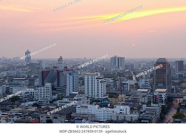Sunset over downtown Bangkok with haze for agricultural burning; from rooftop restaurant of the Siam@Siam Hotel, Thailand