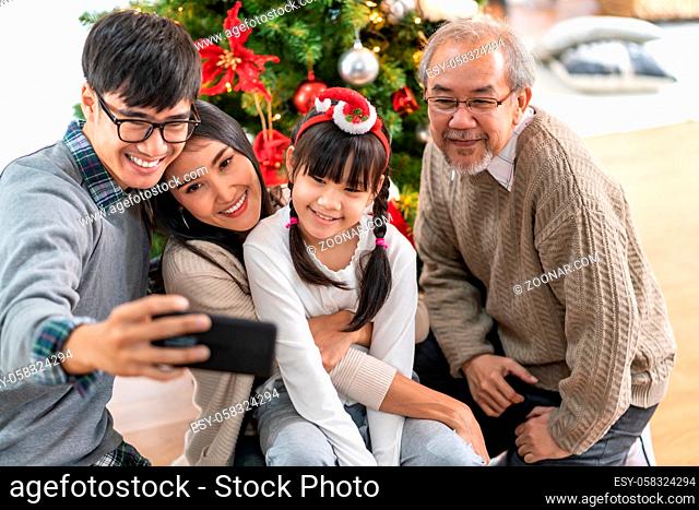 Multigenerational asian Family , Mom Dad daughter girl and grandfather , selfie with a Christmas tree after decorate the Christmas ornament prepare season...