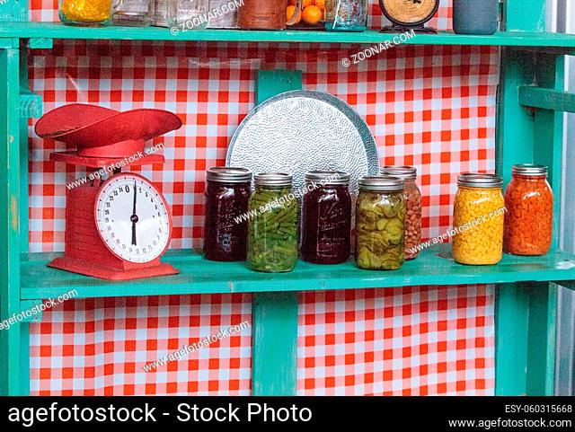 Colorful canned vegetables and fruits in clear glass jars in a farm to table kitchen