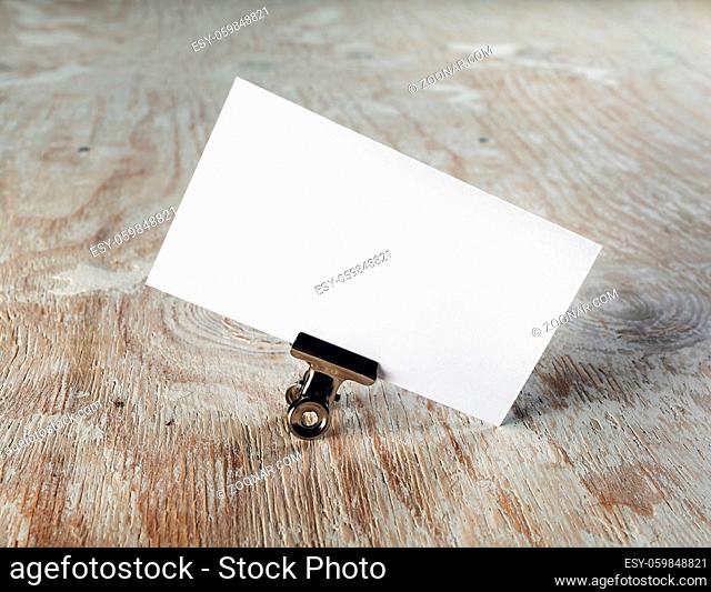 Photo of blank business card with soft shadow on light wooden background. Mock-up for branding identity. Template for graphic designers portfolios