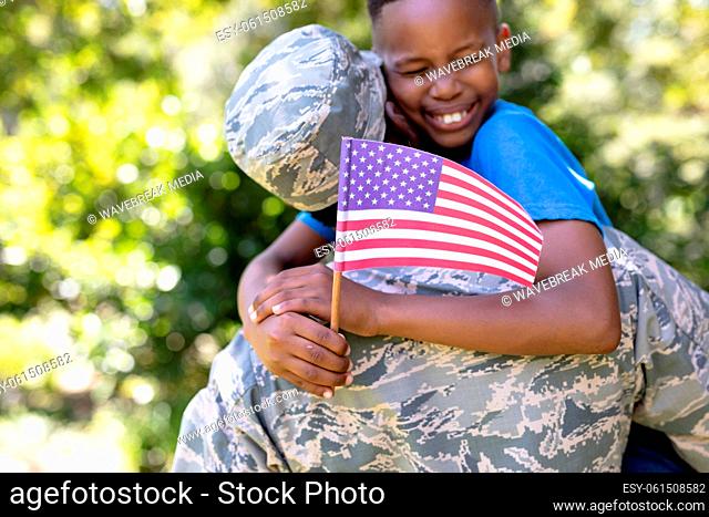 African American man wearing a military uniform holding his son