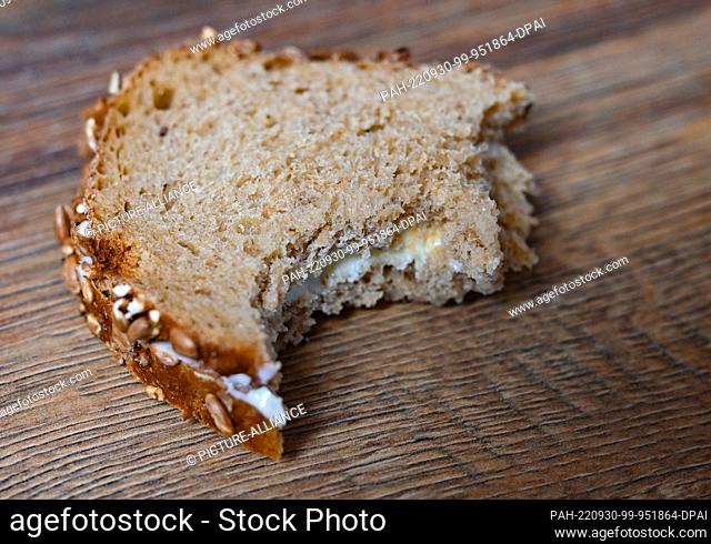 29 September 2022, Brandenburg, Sieversdorf: A folded slice of bread with butter is lying on a kitchen table. A particularly delicious breakfast will be served...