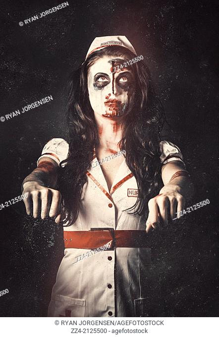 Vintage faded horror portrait of a mad walking dead nurse looking up with braindead expression and arms out stretched