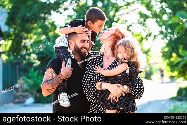 Mom, Dad, little son and daughter have fun in the park