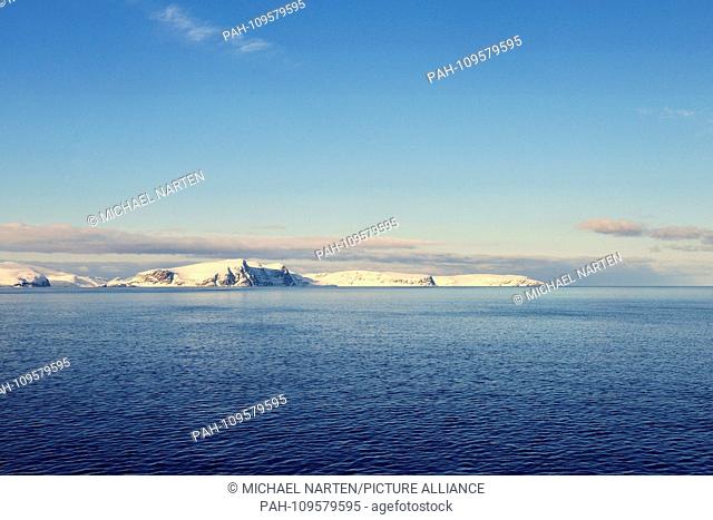 The snow-covered white island Sørøya in the deep blue Norwegian Sea near to the town Hammerfest, 9 March 2017 | usage worldwide