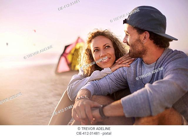 Couple sitting and talking on beach