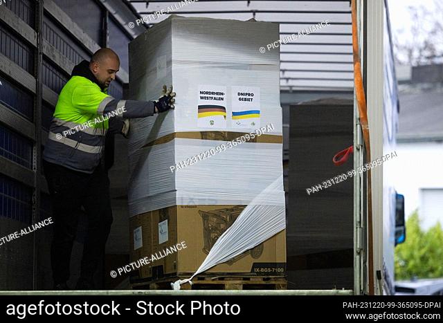 20 December 2023, North Rhine-Westphalia, Cologne: Power generators are loaded into a truck at the ""Blue-Yellow Cross"" donation warehouse