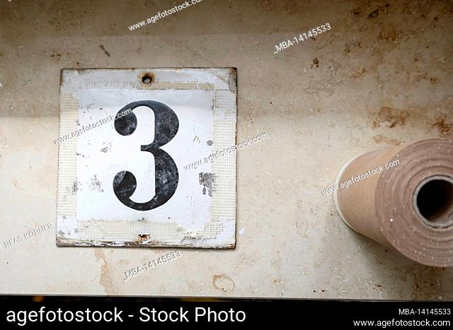 construction site, refurbishment and renovation of an apartment, unscrewed house number on metal sign with the number 3