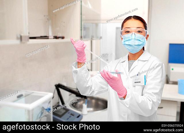 asian female scientist in mask working on vaccine