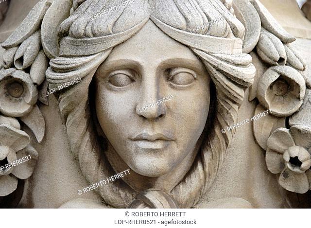 England, London, Kensington Gardens, A carving of a woman's face on a stone urn in the Italian Gardens