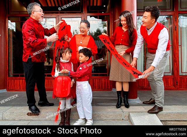 Happy family to stick couplets on the Spring Festival to celebrate the New Year
